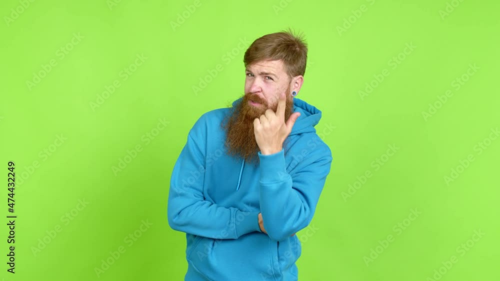Redhead man with long beard looking front over isolated background Redhead man with long beard looking front over isolated background
