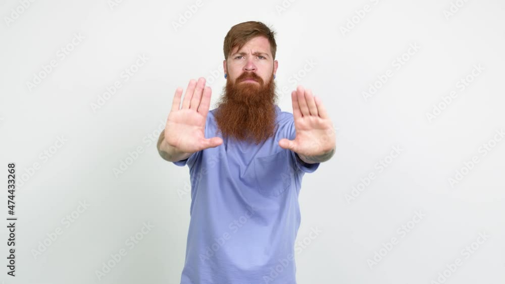 Redhead man with long beard doing stop sign over isolated background Redhead man with long beard doing stop sign over isolated background