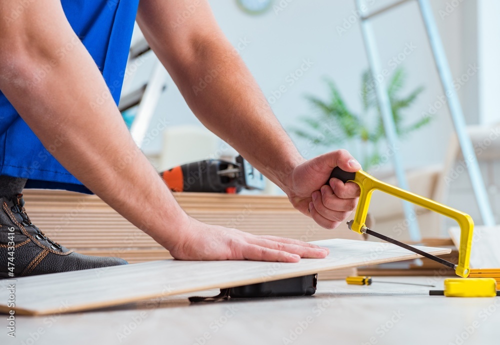 Repairman laying laminate flooring at home