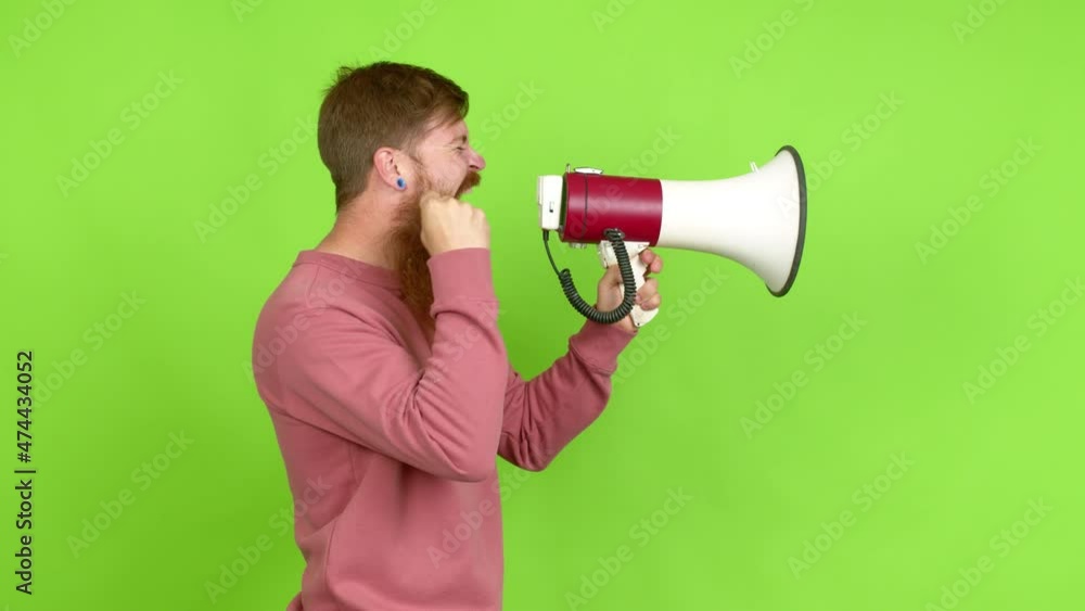 Redhead man with long beard holding a megaphone and shouting over isolated background Redhead man with long beard holding a megaphone and shouting over isolated background