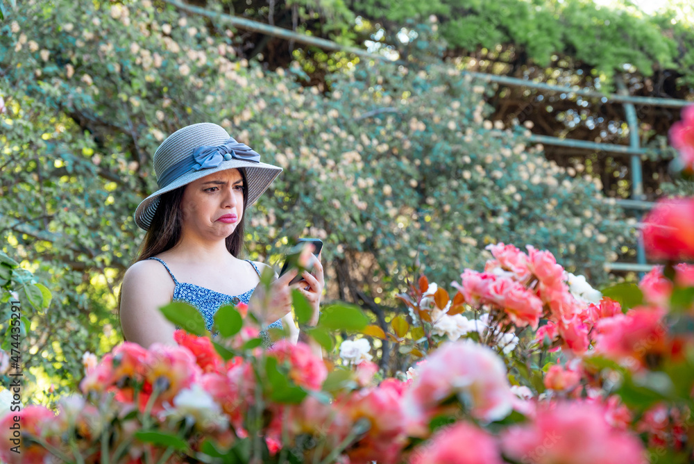 Young woman using a smart phone at park during spring summer season in vacations