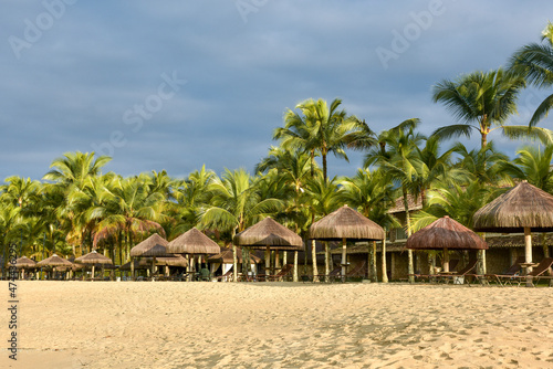 Coqueiros e bangalôs de hotel de luxo na beira mar