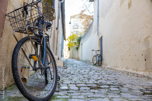 Vélo adossé à un mur dans une petite ruelle pavé de Montpellier (Occitanie, France)