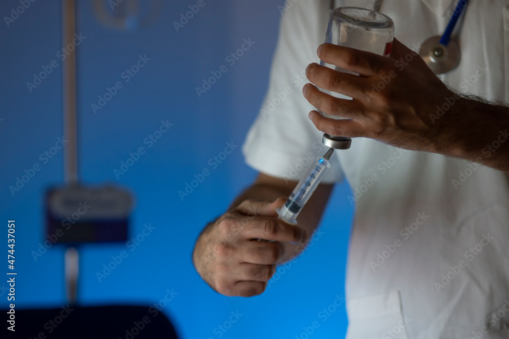 Nurse or doctor with syringe in his hand working during night shift.