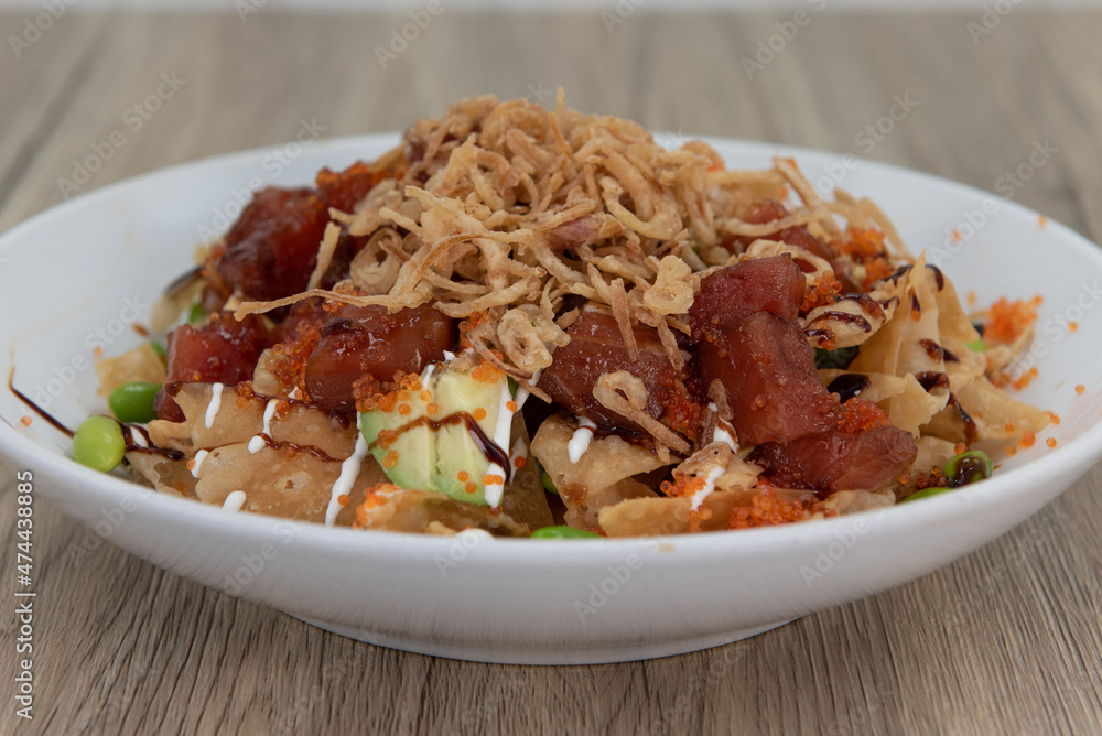 Artistic presentation of ahi poke tuna in a deep bowl over crunchy nachos for a full meal Artistic presentation of ahi poke tuna in a deep bowl over crunchy nachos for a full meal