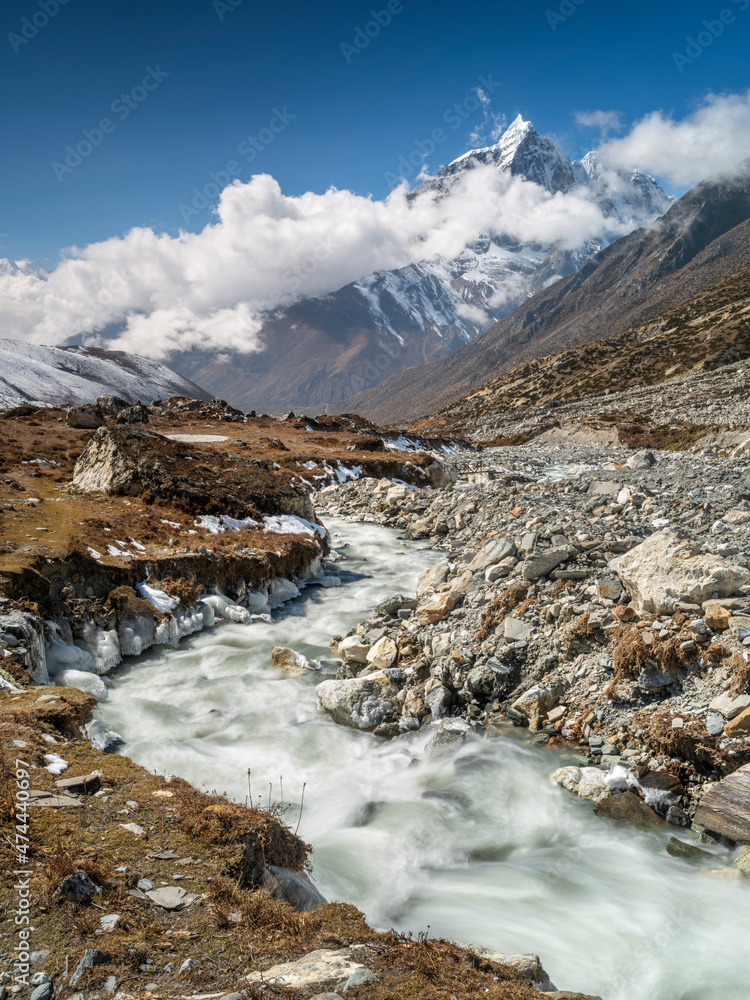 Mountain river in valley in day light with view to summit in Nepal