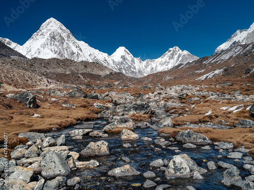 view to mountain creek and view to triangle summit Pumori under blue sky in Nepal photo