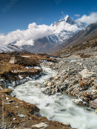 Mountain river in valley in day light with view to summit in Nepal