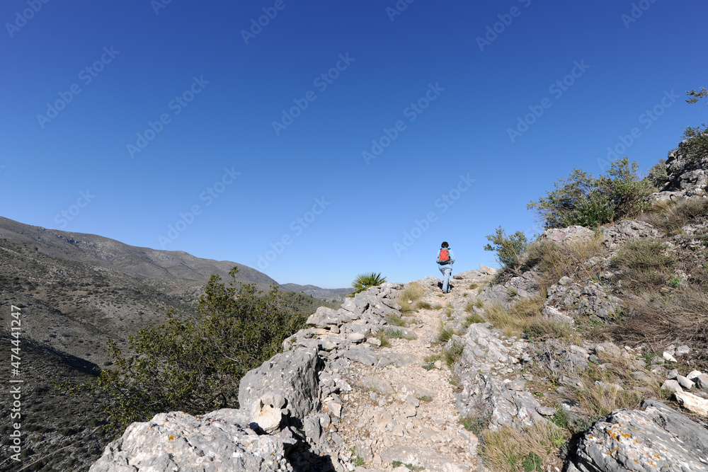 Hiker on Mozarabic trail, Vall de Laguart near Benimaurell, Alicante Province, Spain