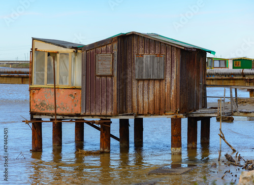An old fishing shack of metal and wood standing in the water at the mouth of the Cornia River in Tuscany, Italy