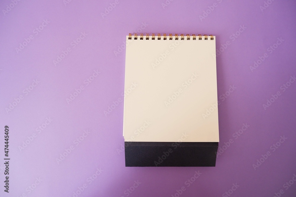 A paper white calendar stands on the table. Mock Up Vector Template. Blank Calendar on purple background. A paper white calendar stands on the table. Mock Up Vector Template. Blank Calendar on purple background.
