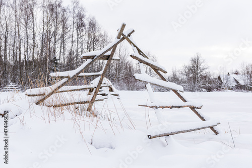 Haystack wooden frame on the field in snowy winter day photo