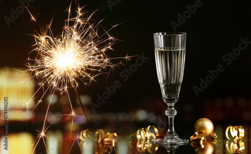 Glass of champagne and Christmas light on dark background