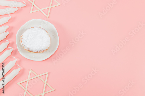 Fotografie, Obraz A donut with powder, white candles and wooden stars of David on a pink