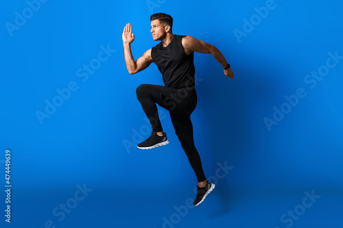 Sporty male runner on color...