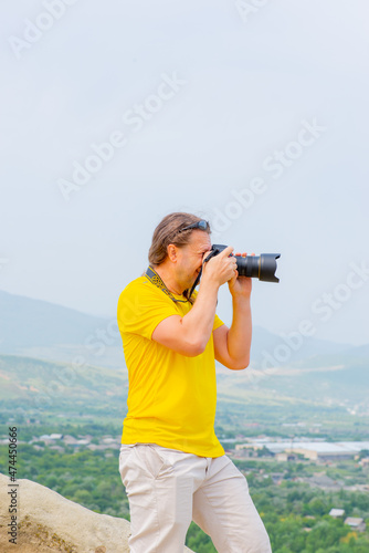 a man in a yellow t-shirt taking pictures