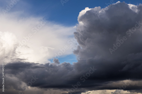 Epic dramatic Storm sky, dark grey and white cumulus clouds on blue sky background texture, thunderstorm. Darkness and light 