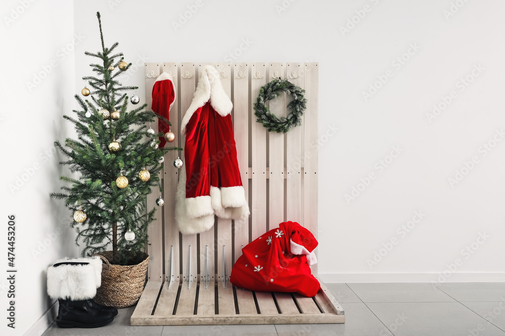 Obraz premium Beautiful Christmas tree and Santa Claus costume in light hallway