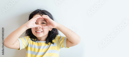 Healthy eyes and vision.Portrait happy asian kid child holding heart shaped hands on eyes.Smiling Girl With Healthy Skin Showing Love Sign. Eye care.Carotene vitamin.Focus, optician doctor, optical. photo
