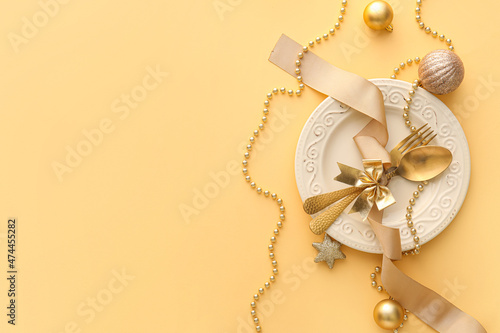 Beautiful Christmas table setting with decor on yellow background