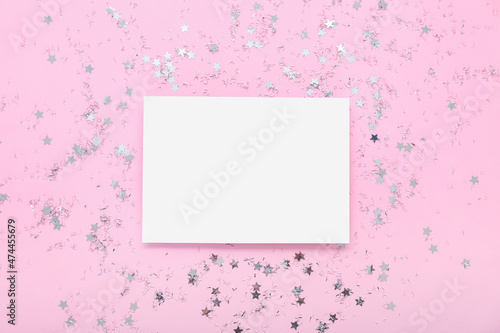 Sheet of paper and beautiful confetti on pink background