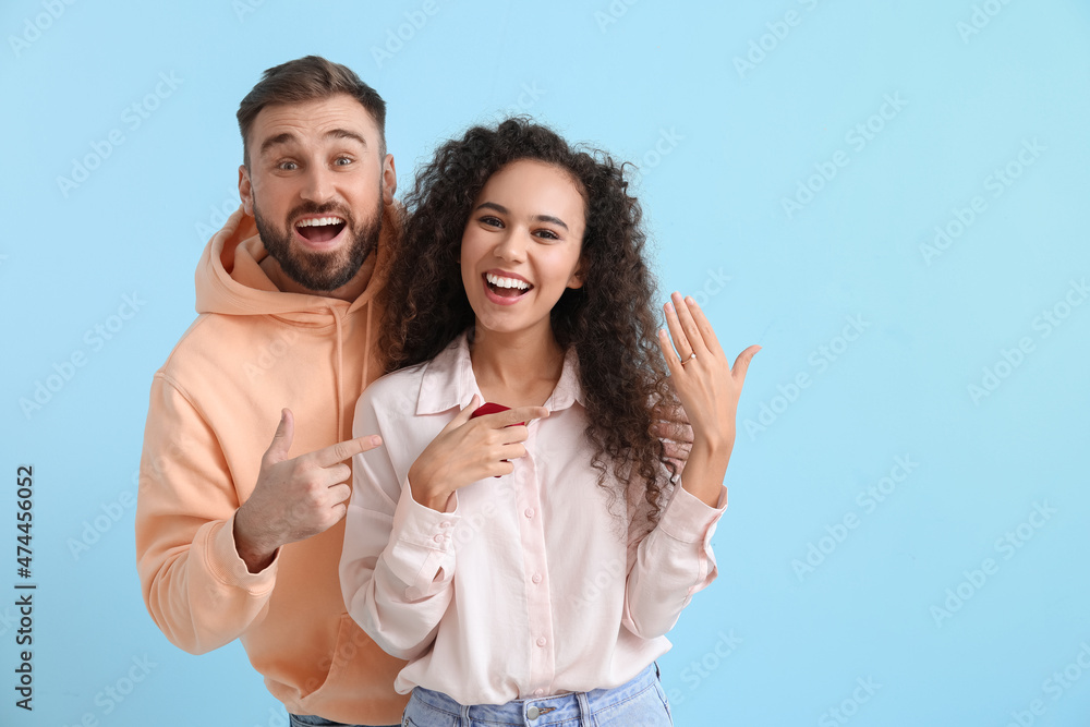 Obraz premium Happy engaged young couple after marriage proposal on color background