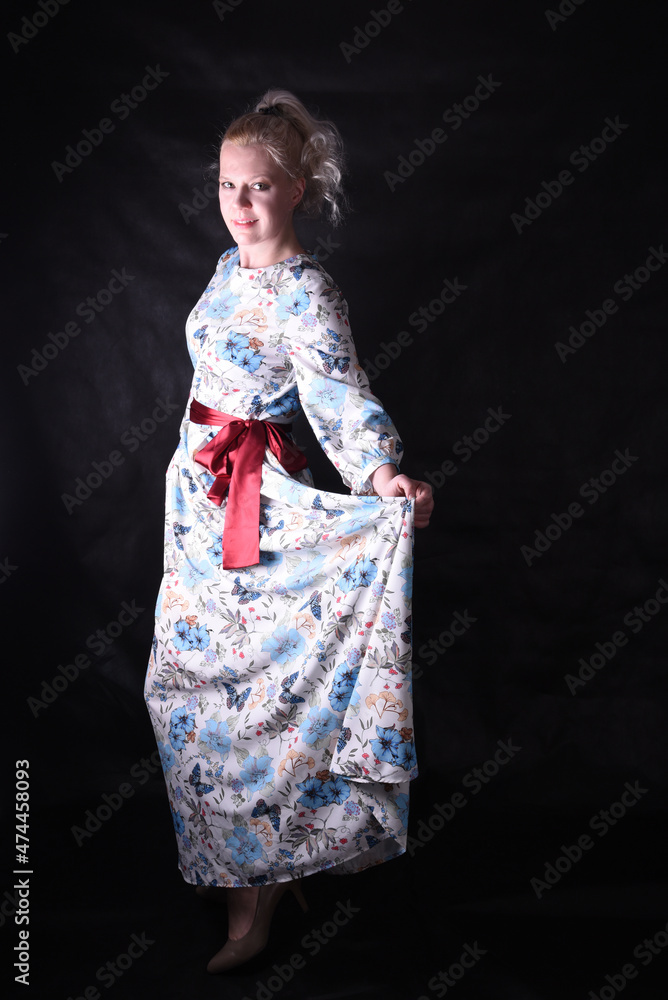 Portrait of a beautiful blonde on a black background in a studio in semi-darkness in a beautiful dress Portrait of a beautiful blonde on a black background in a studio in semi-darkness in a beautiful dress