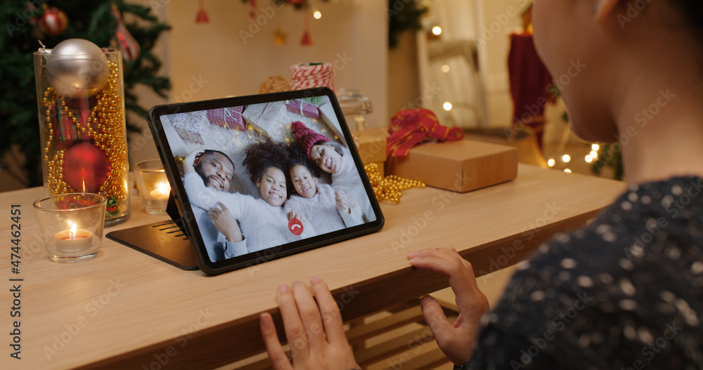X'mas asia happy woman relax smile laugh greet in digital tablet screen remote talk to child kid friend at night online video VoIP party sit on cozy sofa at home enjoy good warm time winter season.