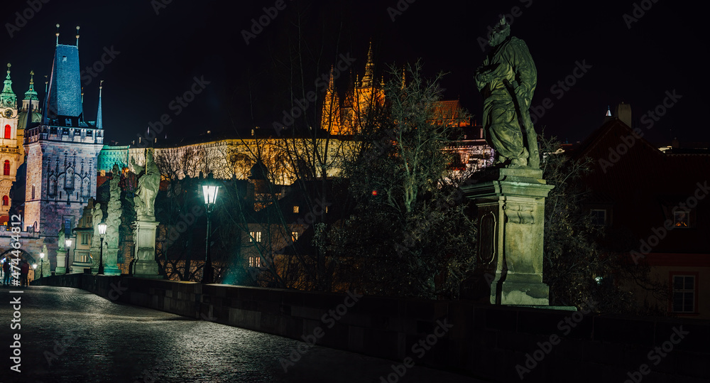Fototapeta premium street lamps and old tower on Charles Bridge in the city of Prague at night 2021