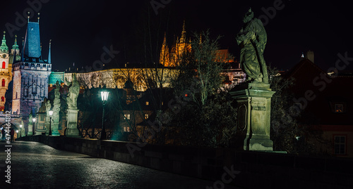 street lamps and old tower on Charles Bridge in the city of Prague at night 2021