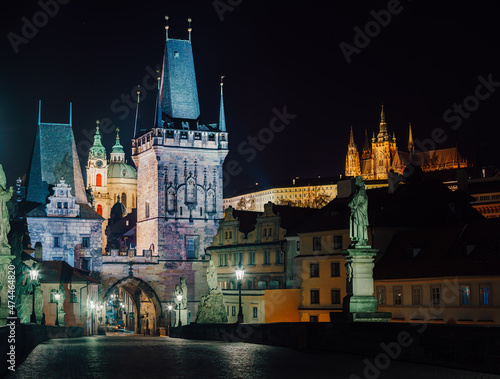 street lamps and old tower on Charles Bridge in the city of Prague at night 2021