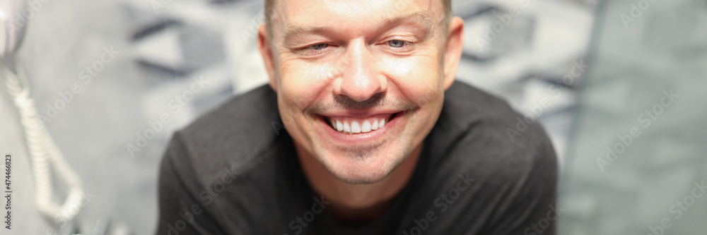 Young happy man sitting on toilet and smiling Young happy man sitting on toilet and smiling