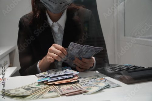 Almaty, Kazakhstan - 11.16.2021 : The bank's cashier recalculates banknotes of different denominations before the exchange photo