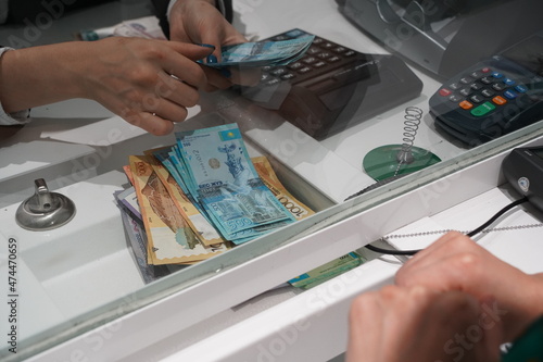 Almaty, Kazakhstan - 11.16.2021 : Counting and transfer of banknotes through the bank's cash desk