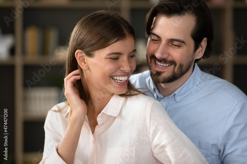 Happy excited young couple in love having fun at home, dancing to music close together, smiling, laughing, enjoying leisure, activity in new apartment. Relationship, romance, flirt concept