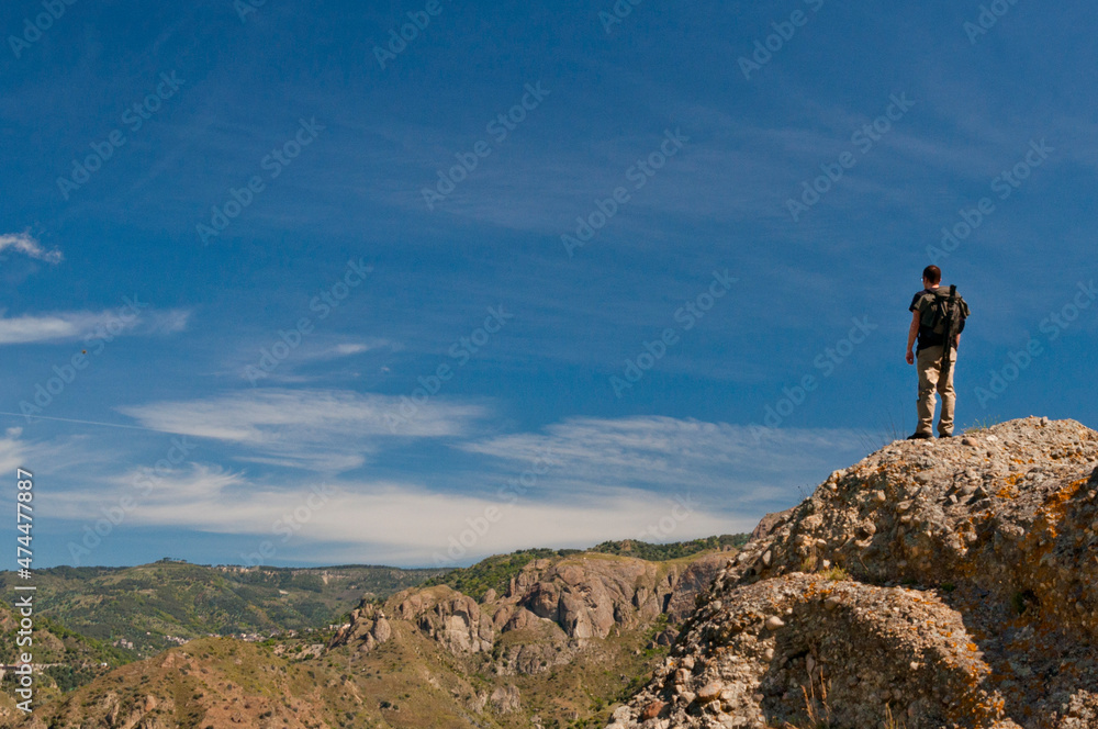 Escursionista in piedi di spalle tra le colline