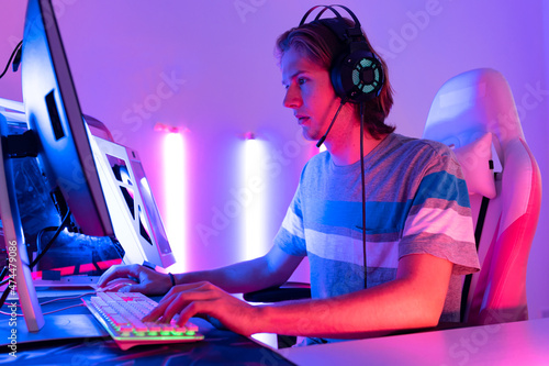 young  playing game online at home. Gamer  controlling joystick for video game. Teenage girls leisure game in neon light room at home. © anon