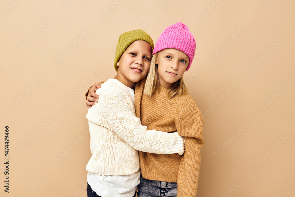 boy and girl together in multi-colored hats fun casual wear isolated background