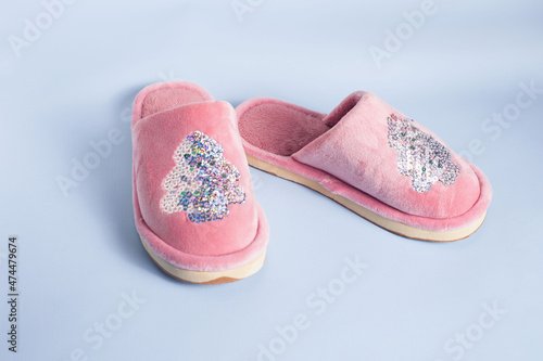 on a blue background there are roh children's slippers with a pattern of sequins in the form of a Christmas tree