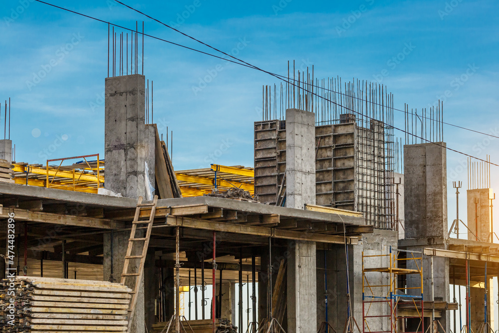 Extensive scaffolding providing platforms for work in progress on a new apartment block,Tall building under construction with scaffolds,Freestanding tower crane on a building site