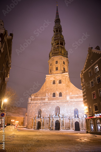 Winter evening on the main square of the city, street by evening lights, before Christmas, New Year. Catholic church, tower. Riga, Latvia.