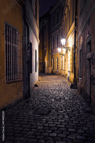 view of a dark and illuminated cobblestone street in the old town of prague at night 2021 © svetjekolem