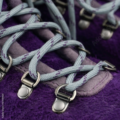 Violet suede hiker boots with metal eyelets and lacing with blue laces close up