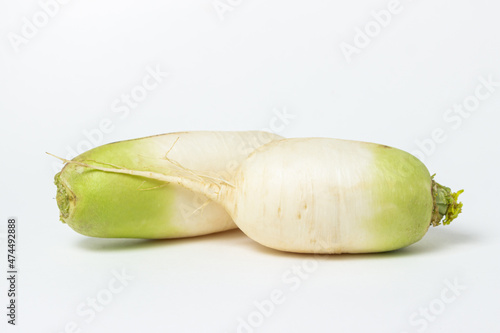 White radish on a white background. Delicious and healthy vegetables. Vegetarian food.