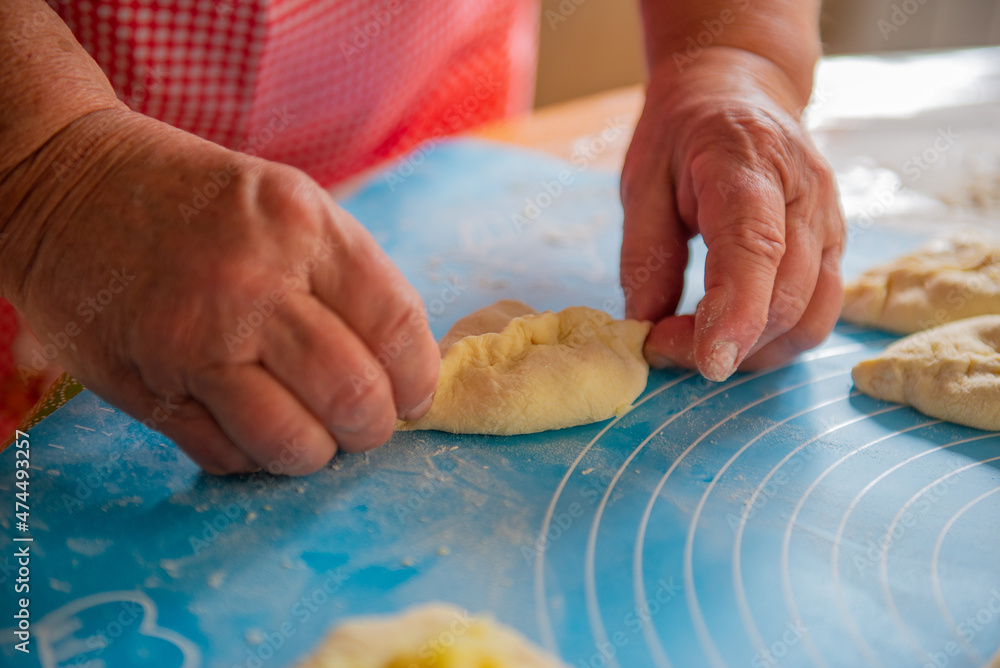 a woman makes a lot of pies out of dough. High quality photo