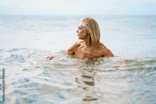 Mature woman in good shape bathing in the sea.