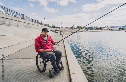 Person with a physical disability in a wheelchair fishing from fishing pier.