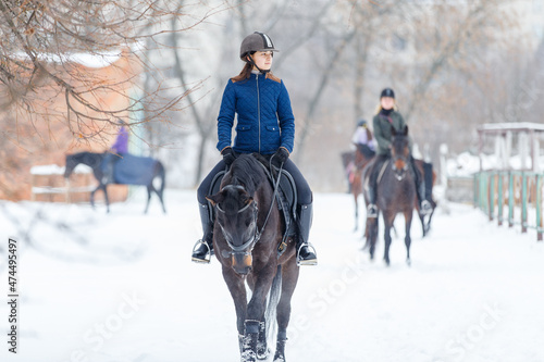 Teenage girl riding horse at the ranch in winter.