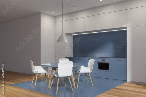 White and blue kitchen interior with table and chairs, wooden floor