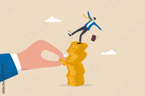 Investment risk from stock market crash, pull money or liquidity back, market volatility, unstable and uncertainty concept, giant hand pull back money from coin stack causing investor to fall down. photo
